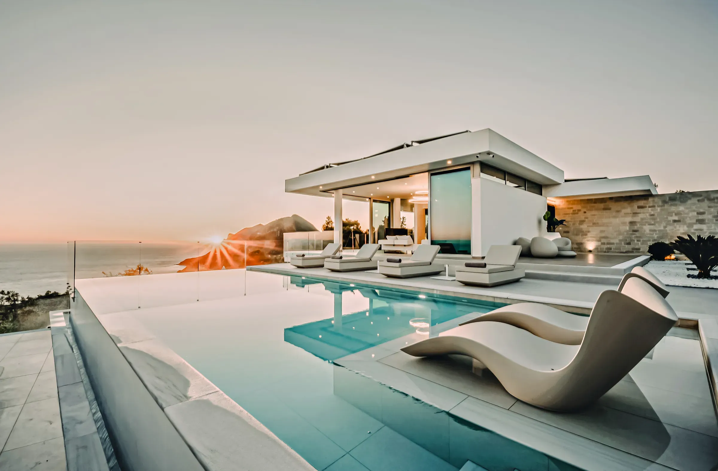 Sun loungers by the infinity pool at sunset