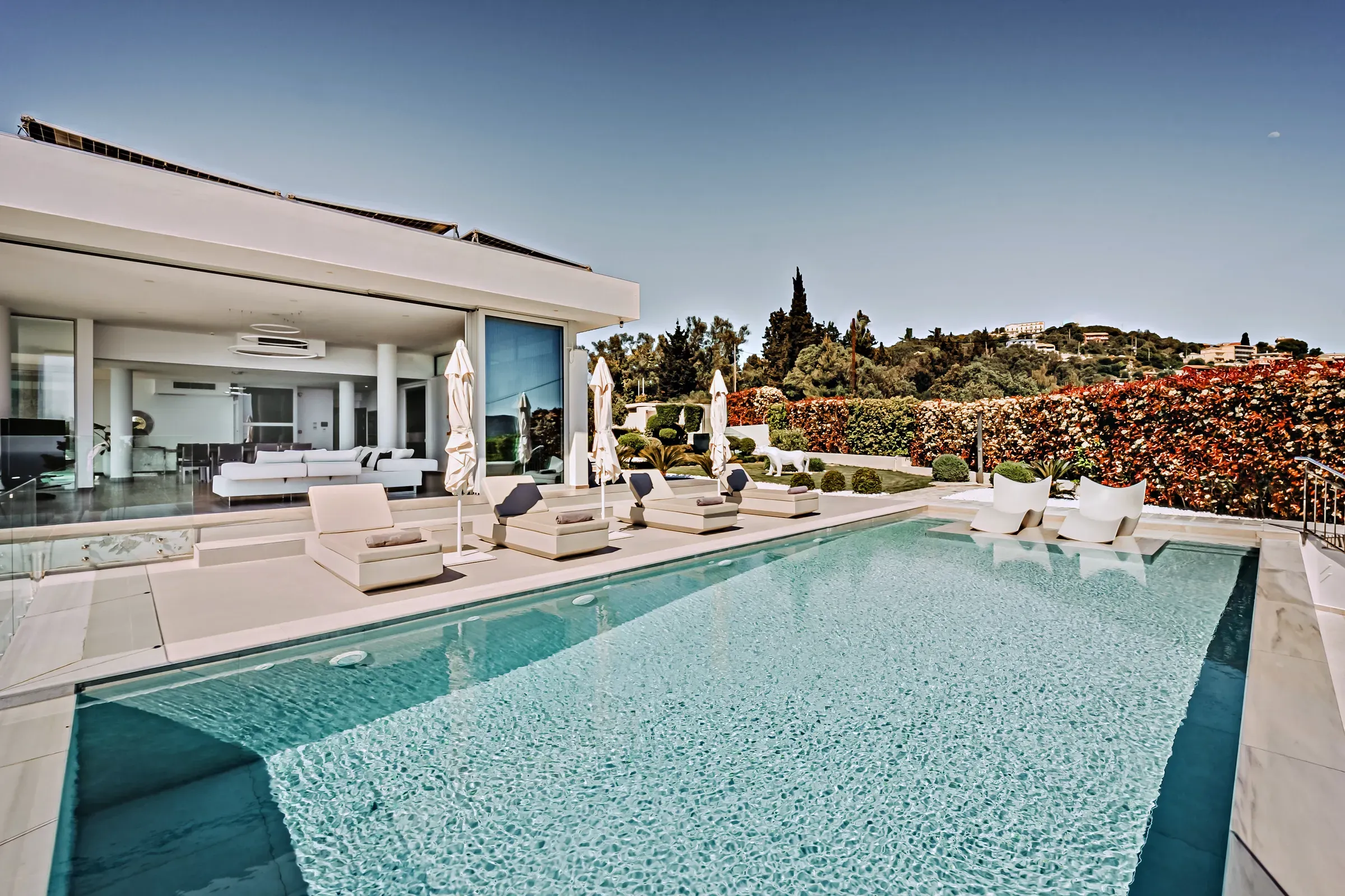 Poolside with flowering hedge and sea view