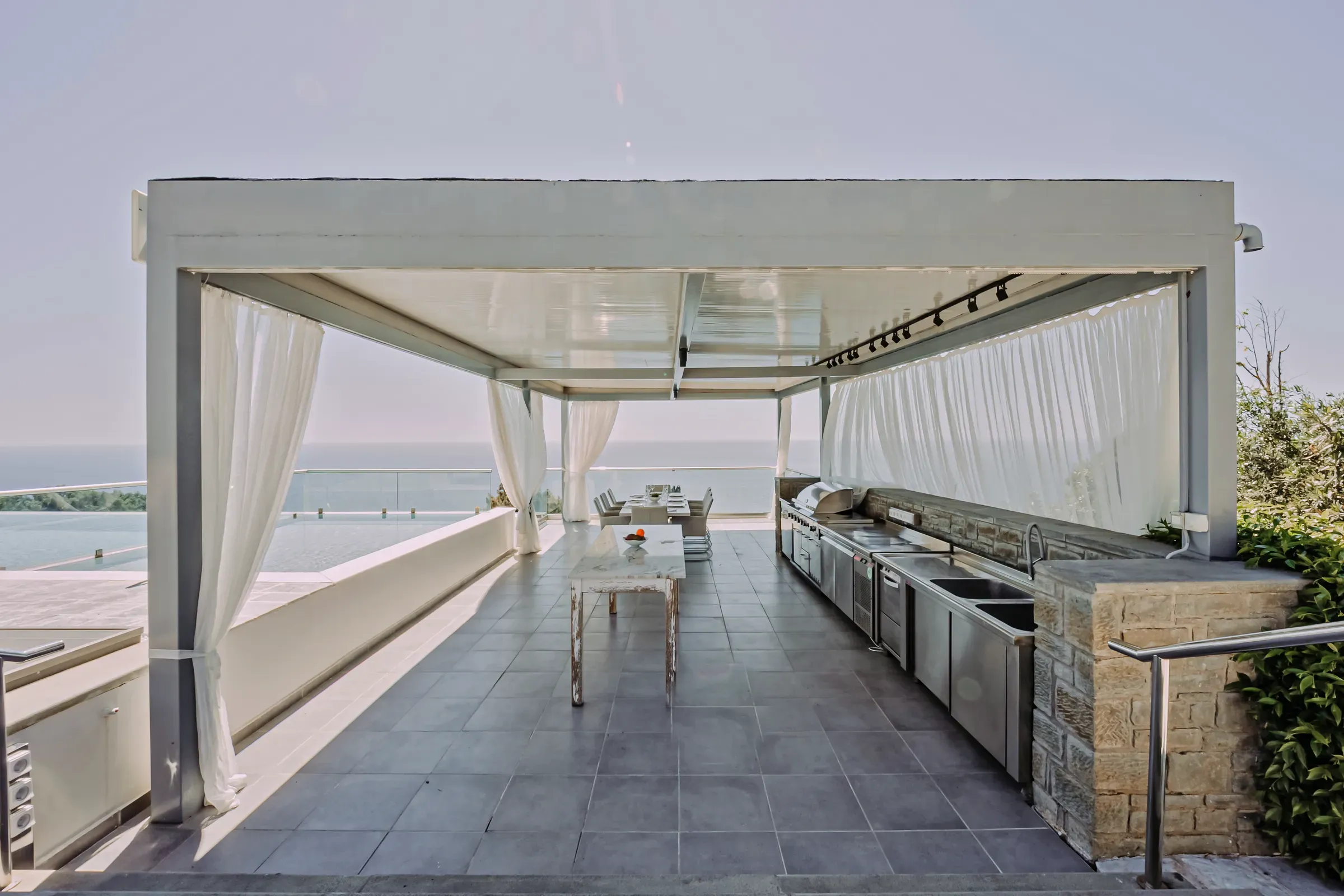 Covered outdoor lounge with flowing curtains
