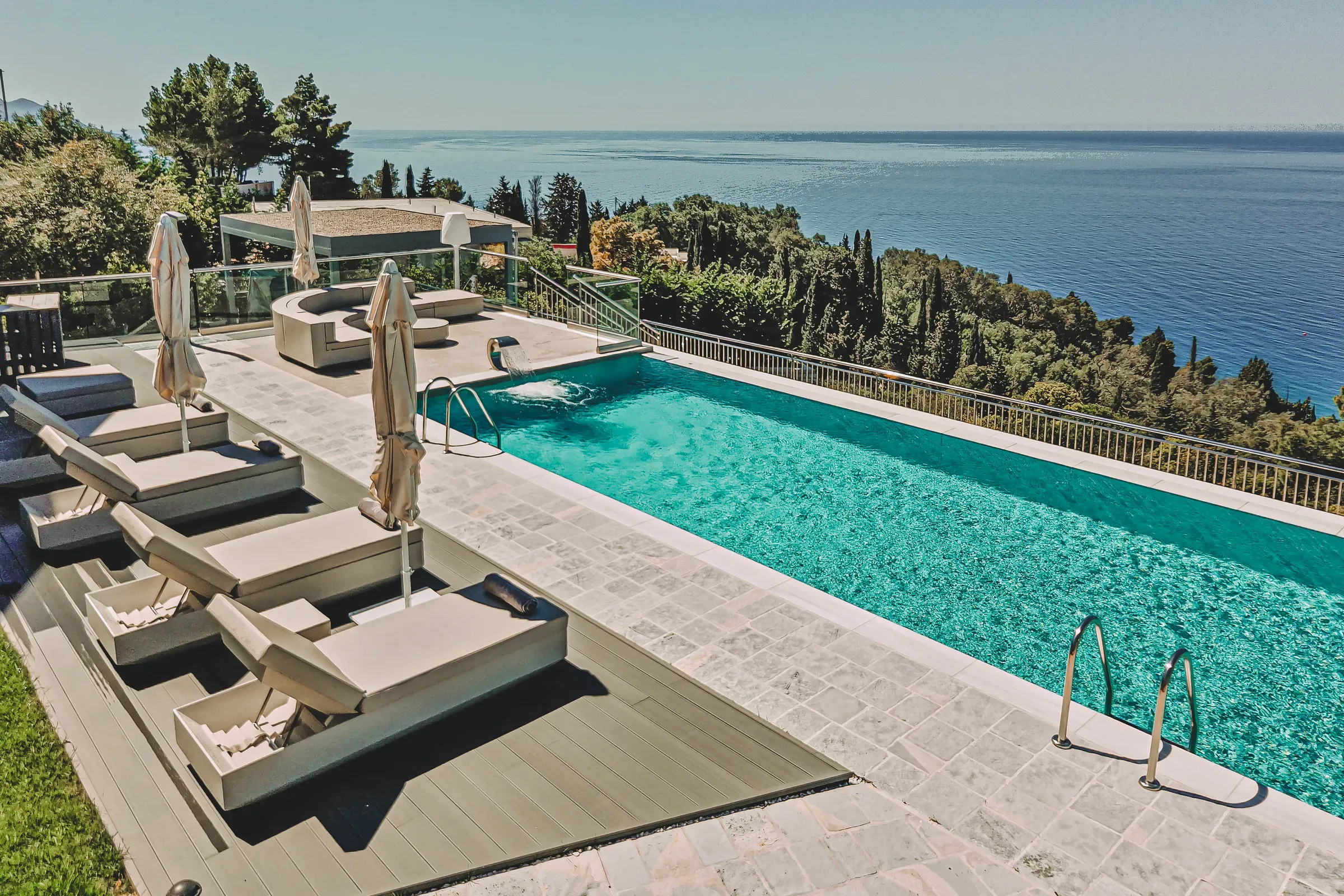 Pool with sun loungers and sea view