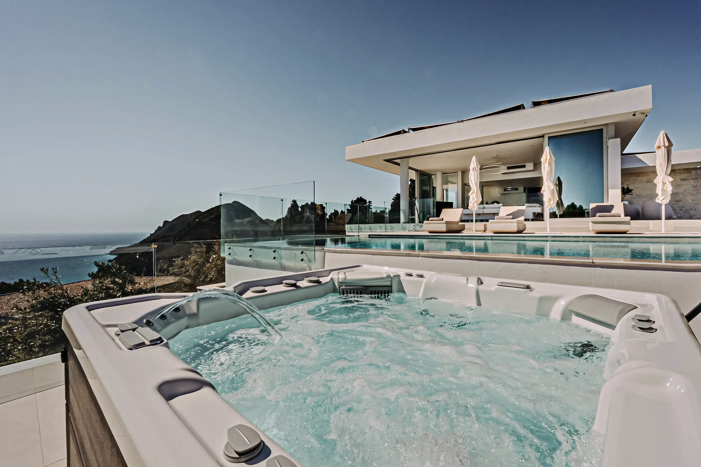 Outdoor jacuzzi with villa and sea view
